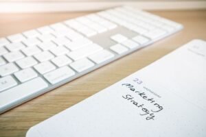 Paper labeled “Marketing Strategy” placed on top of a computer keyboard.